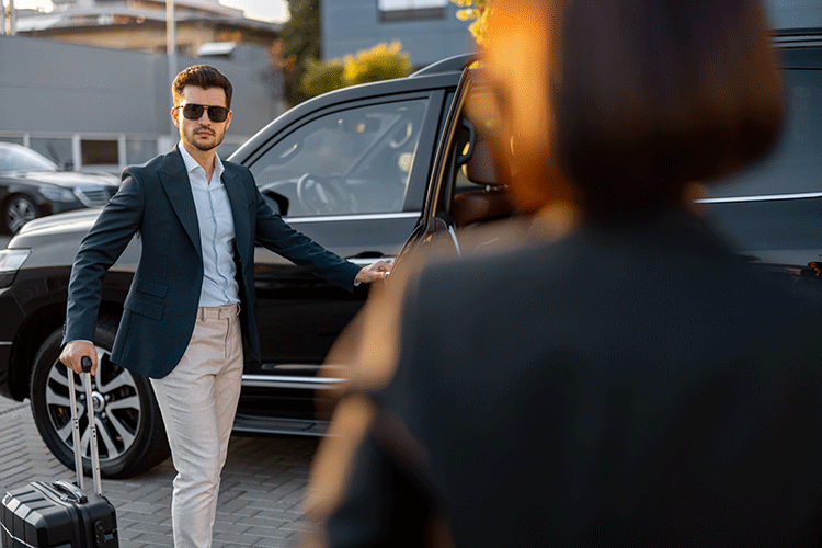 A professional chauffeur opens the car door for a male client with luggage, providing a premium Istanbul limousine transfer service.