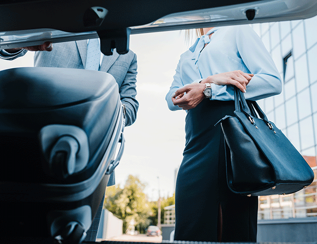A Limousine Plus chauffeur providing full luggage assistance for a female client, ensuring a seamless private transfer in Istanbul.