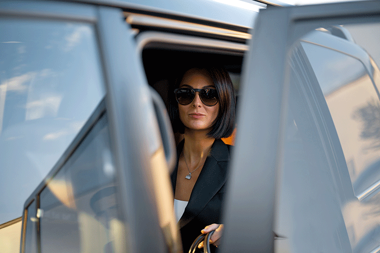 Luxury Taxi in Istanbul 1 A stylish female passenger getting out of a luxury Limousine Plus van, arriving at her destination in Istanbul.