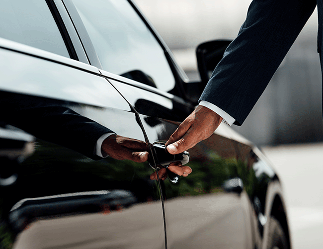 Close-up of a Limousine Plus chauffeur opening the door of a luxury vehicle, demonstrating attention to detail and impeccable service.
