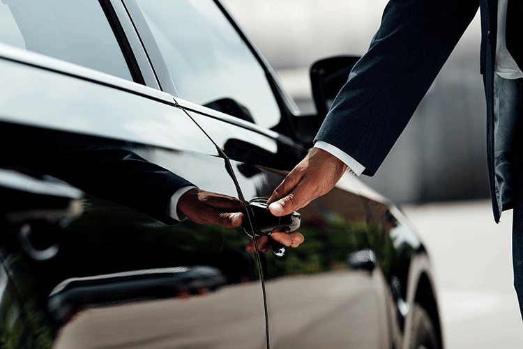 Close-up of a Limousine Plus chauffeur opening the door of a luxury vehicle, demonstrating attention to detail and impeccable service.