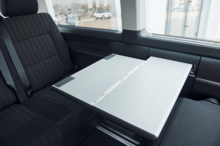 Interior of a Mercedes Vito VIP transfer vehicle with a foldable work table