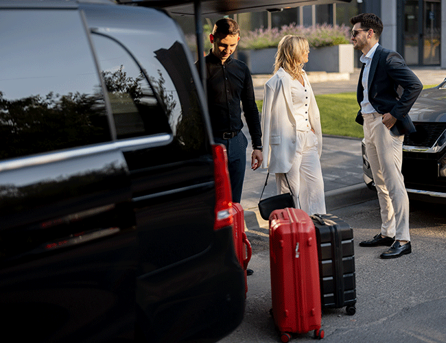 A chauffeur assisting a stylish couple with their luggage by a luxury VIP van, perfect for group airport transfers in Istanbul.