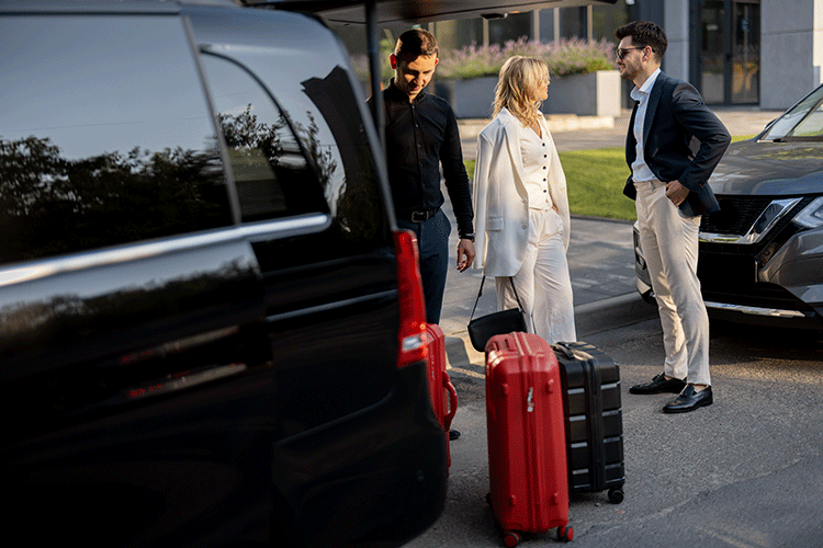 A chauffeur assisting a stylish couple with their luggage by a luxury VIP van, perfect for group airport transfers in Istanbul.